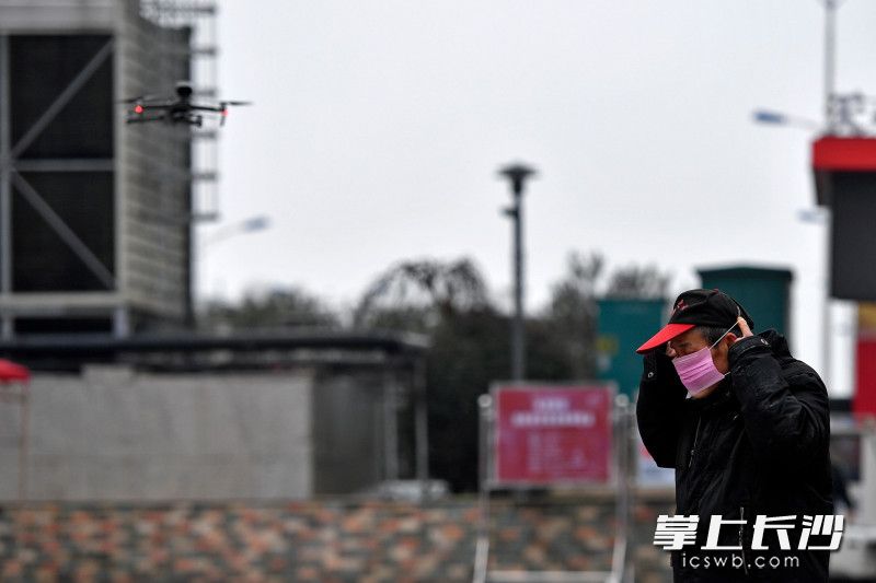 今日上午，黄兴南路步行街中心广场附近，在无人机的劝导下，一名市民戴上了口罩。
