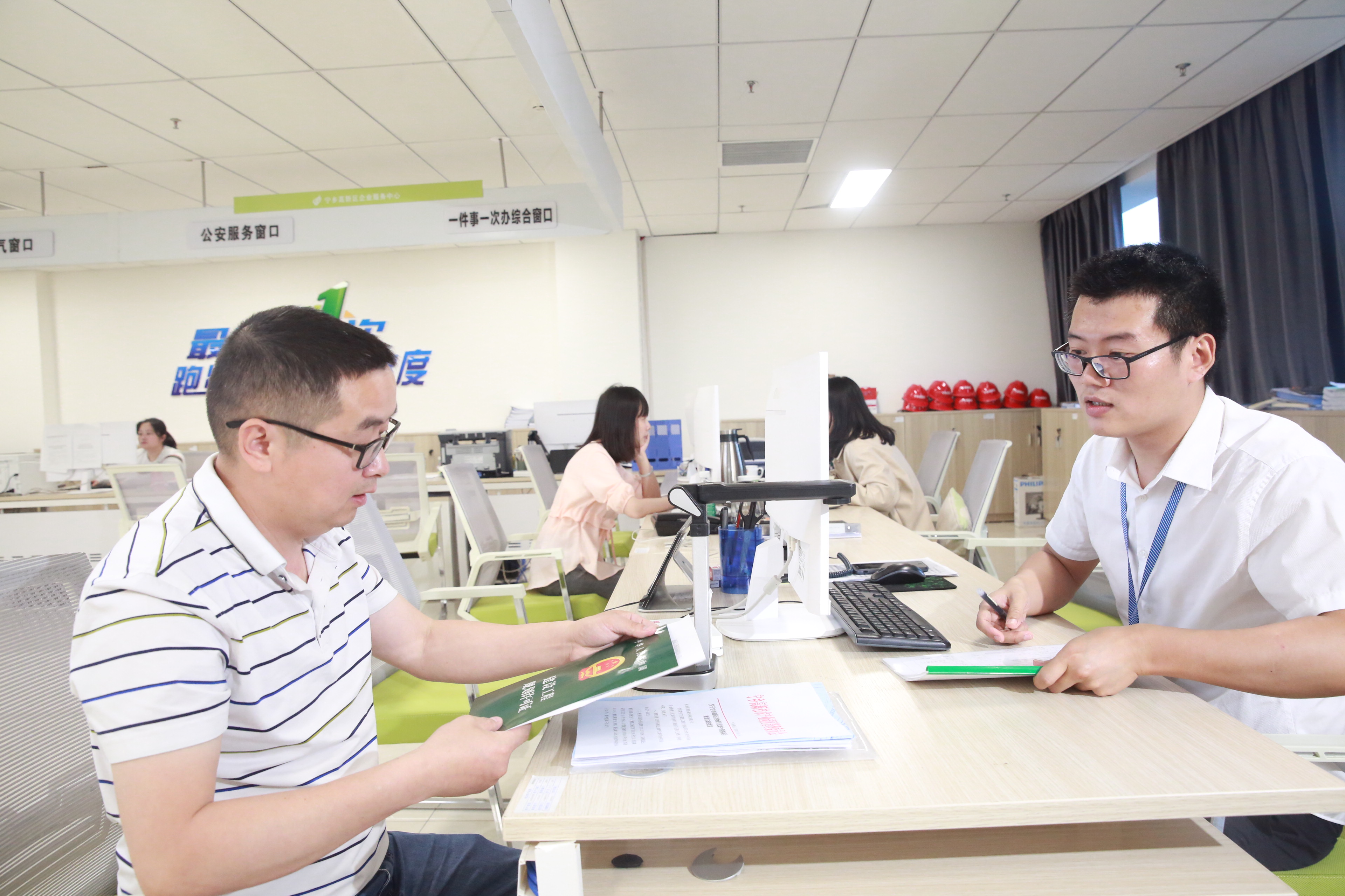 5月8日上午，宁乡高新区企业服务中心窗口工作人员杨赞将办好的《建设工程规划许可证》交给企业代办员。长沙晚报通讯员 刘石江 摄