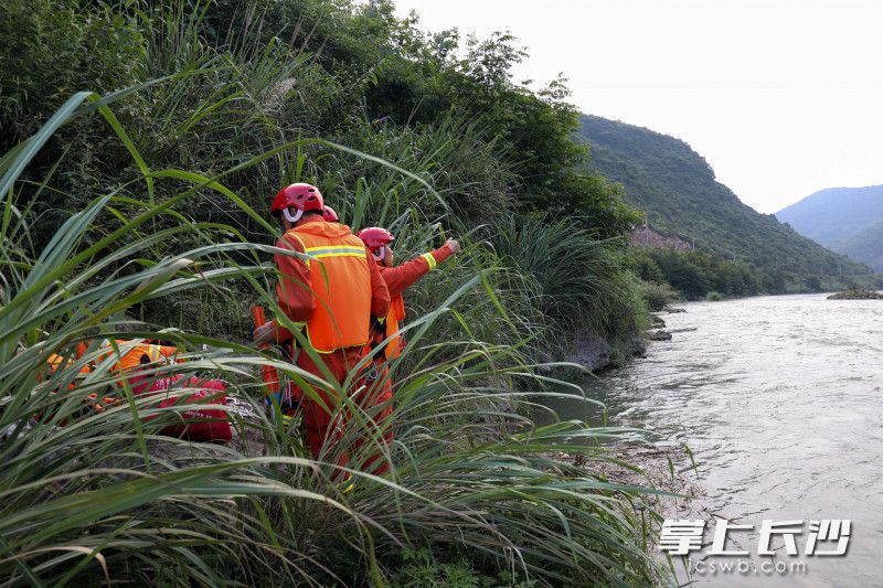 消防员向河中渔民求助，共同营救河水中的被困男子。均为张家界消防供图