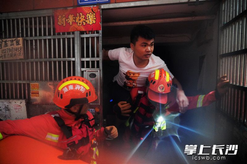 在岳阳楼区，消防员将楼道中的被困群众背上皮划艇。长沙晚报通讯员 黎翔 摄