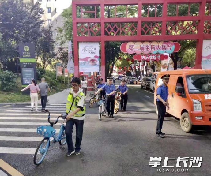 湖南米粉街内，芙蓉区行政执法人员和共享单车企业志愿者对共享单车进行清运。均为芙蓉区行政执法局供图