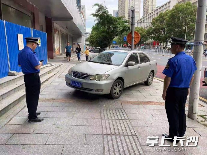 芙蓉区行政执法人员正在对占道违停车辆进行处置。