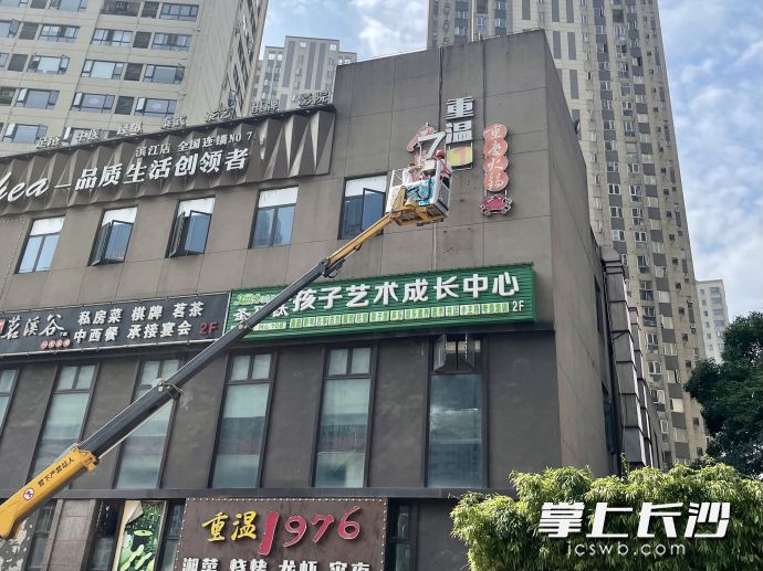 今日上午，岳麓区城管执法人员组织施工人员对含光路一处违规招牌实施拆除。长沙晚报全媒体记者 唐朝昭 摄