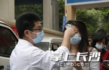 在桔子洲三真社区卫生服务中心新增设的新冠疫苗接种点入口，工作人员对前来接种新冠疫苗的市民进行初步预检。均为长沙晚报通讯员 杨婕 供图