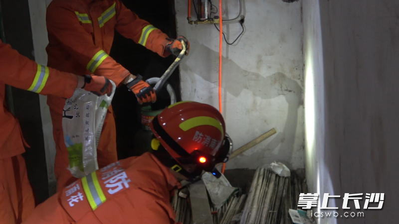 消防员利用捕蛇工具将蛇制服。长沙消防 供图