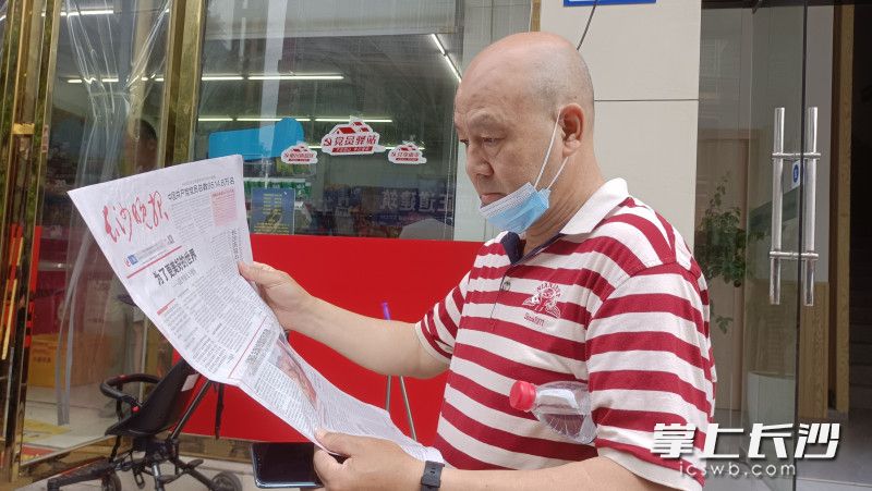 在长沙，街头巷尾，市民认真阅读7月1日当天的《长沙晚报》。长沙晚报实习生 曾雅文 摄