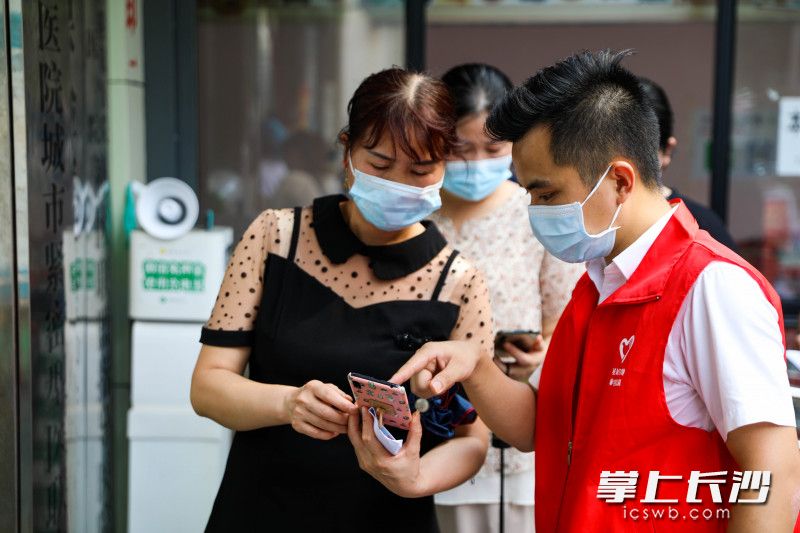 8月3日下午，在荷花园街道社区卫生服务中心门前，星城学雷锋志愿者们为市民解答新冠疫苗接种问题。