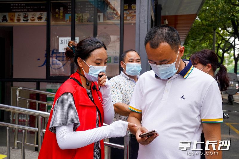 8月3日下午，在荷花园街道社区卫生服务中心门前，星城学雷锋志愿者指导市民正确预约新冠疫苗接种流程。