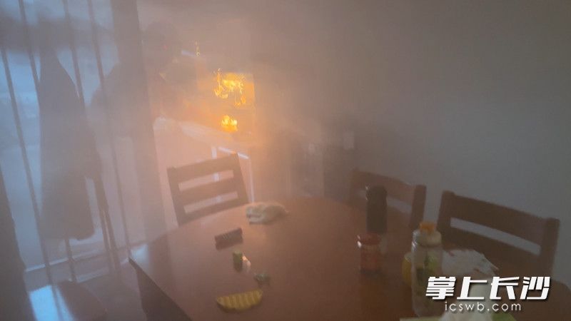 房间内满是浓烟，消防救援人员控制火势。