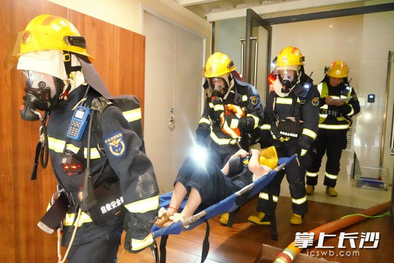 “被困人员”被消防救援人员使用担架转移至安全地带。