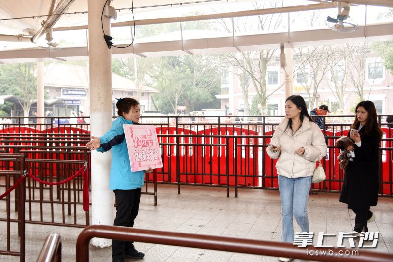 工作人员引导女性游客通过快速候车通道上车。 工作人员引导女性游客通过快速候车通道上车。