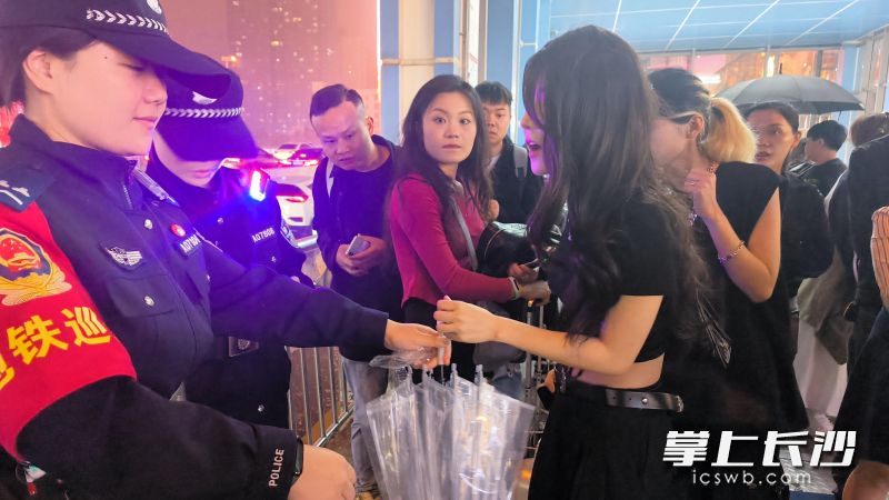 民辅警给游客发伞。 民辅警给游客发伞。