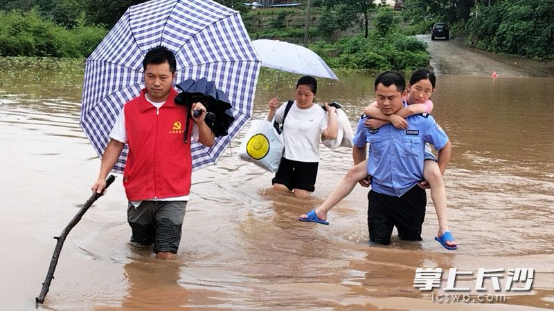 7月1日下午4点，泸溪县公安局浦市派出所驻银井冲村村干部与辅警洪水中转移被困群众。 图片均由通讯员 湘公宣 供图