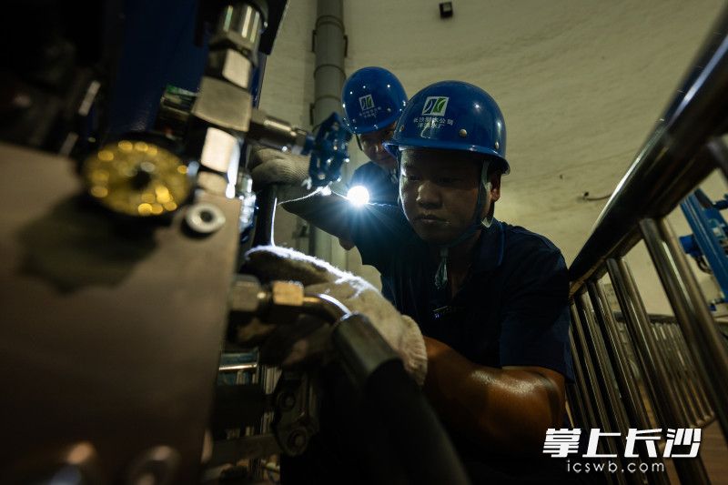 周栋宇和汤辉对设备进行维修。