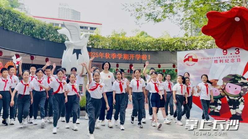 在砂子塘小学，“胜利花”设计师张丽老师（中）教少先队员们做好胜利花。长沙晚报通讯员 李静 摄