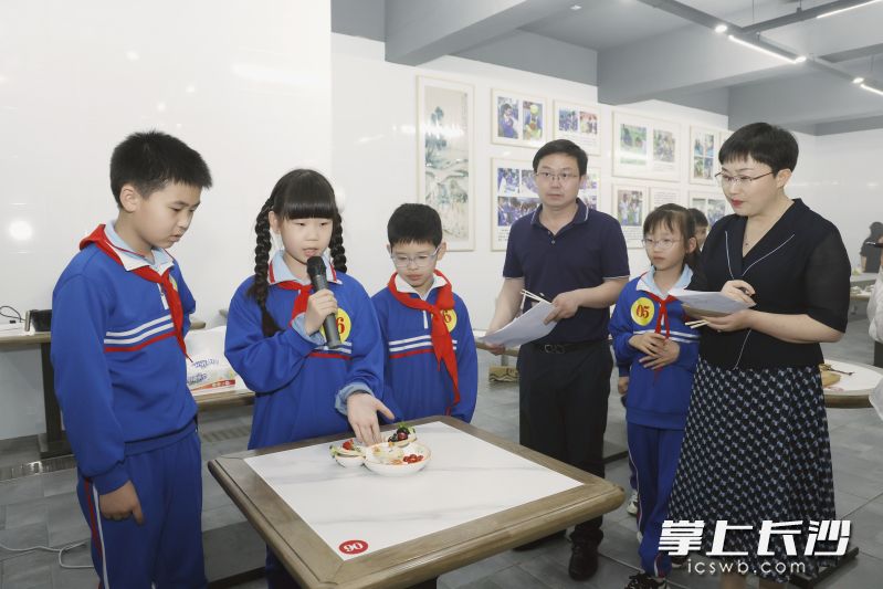 劳动技能大赛上听小选手们介绍自制的菜品。