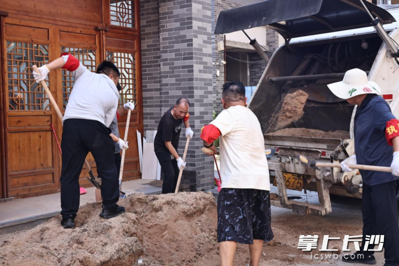 灰汤镇“三长”及志愿者在相里清理杂物。