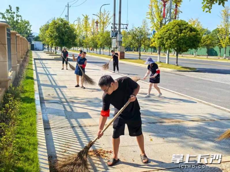 灰汤镇“三长”及志愿者精细化清扫主干道。