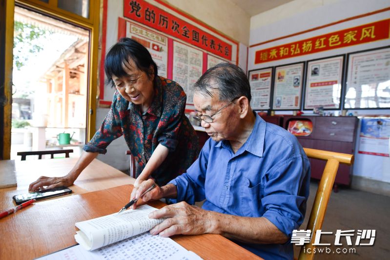 退休25年，伍编长和爱人坚持手绘板报，传播红色文化。