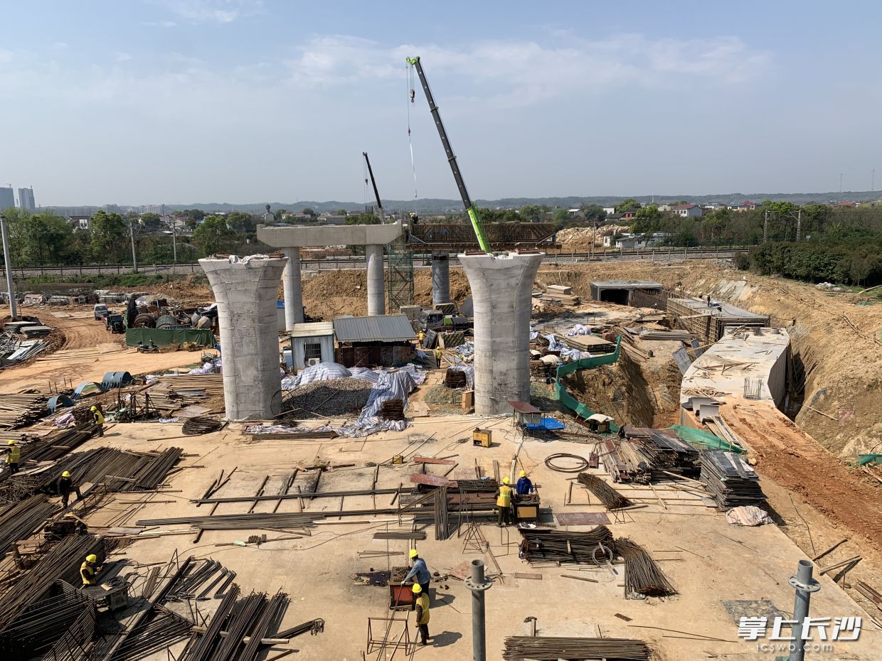 在京广铁路东侧，工人们正在进行预制梁模板试拼、墩柱盖梁等施工。