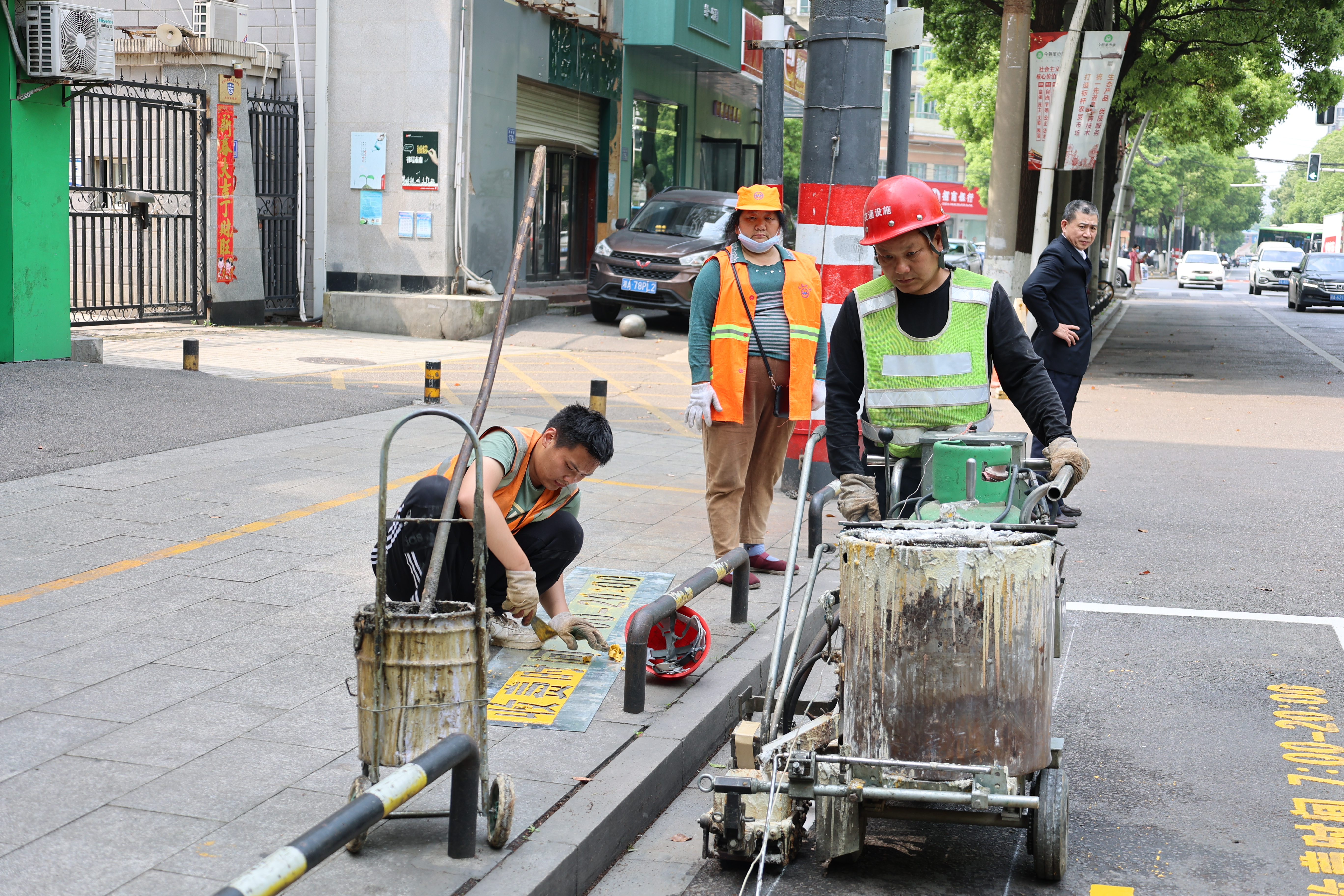 在芙蓉区东二环线附近湘湖中路上，交通设施工作人员正在施划停车位。