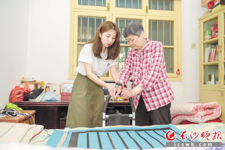 社区工作人员正在首批改造完成的刘翠华老人家教她使用智能设备。 长沙晚报全媒体记者 陈飞 摄