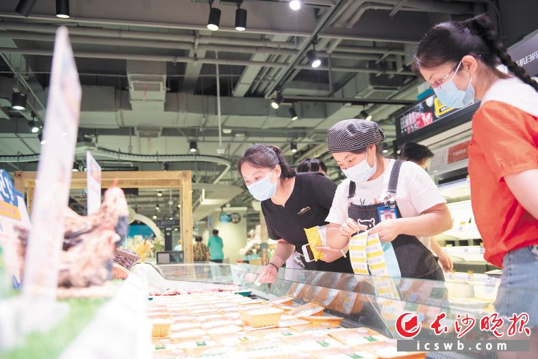 市民佩戴口罩在超市选购食材。目前，各商超食品供应充足，市民无需囤货。均为长沙晚报全媒体记者 郭雨滴 摄