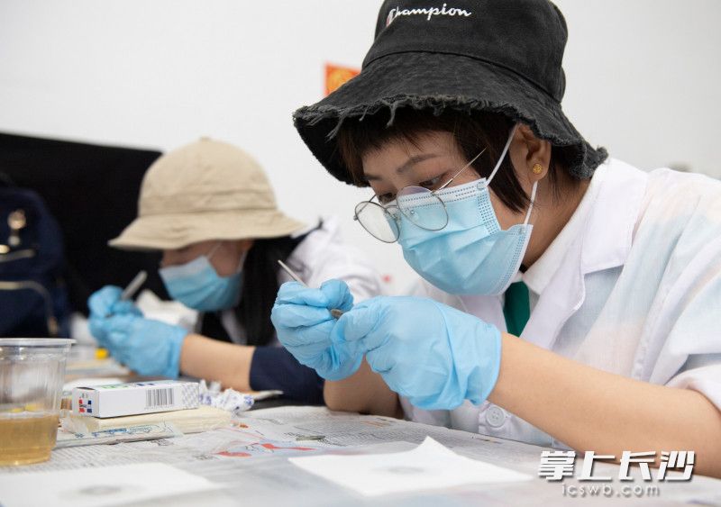 两位市民正在体验修复钱币。