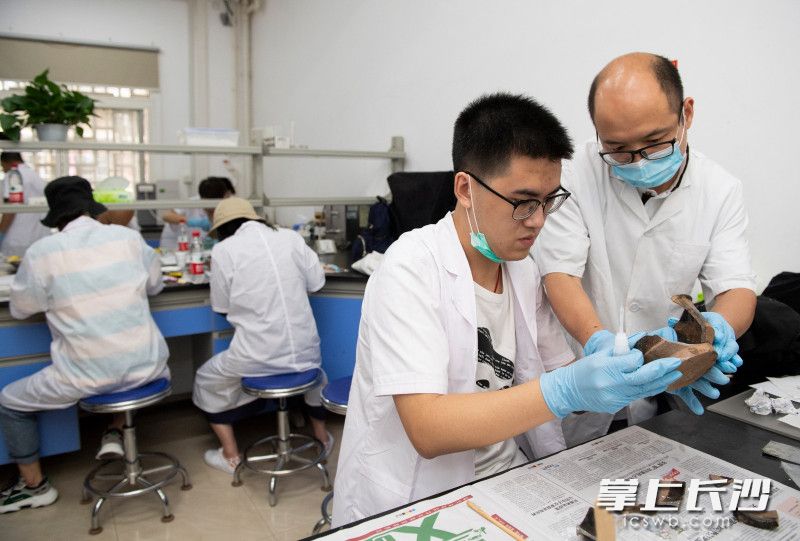 长沙市文物考古研究所文化遗产日公众活动中，市民正在体验修复文物。