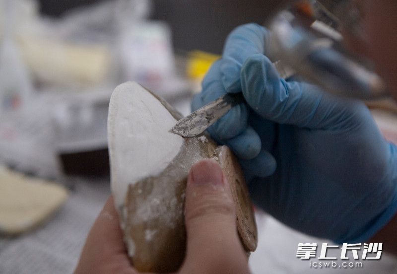 修补残缺的陶器。