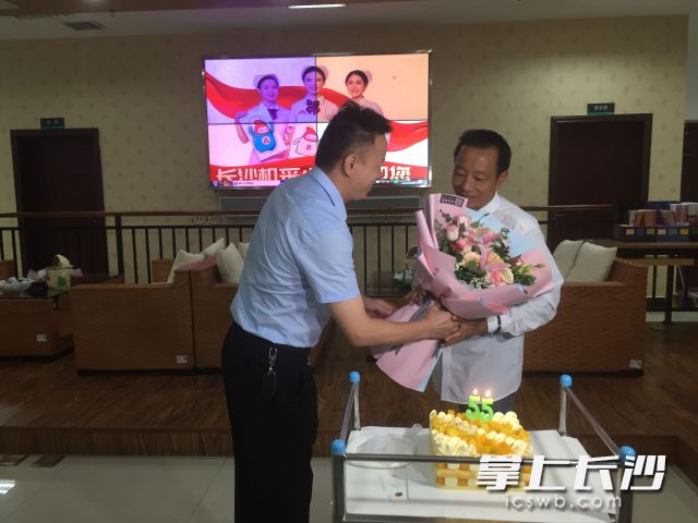 长沙血液中心有关负责人为费必武送上鲜花，祝他生日快乐。长沙晚报全媒体记者 朱炎皇 实习生 邹菁 摄影报道