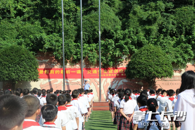 交警给放暑假前的学生上交通安全课。