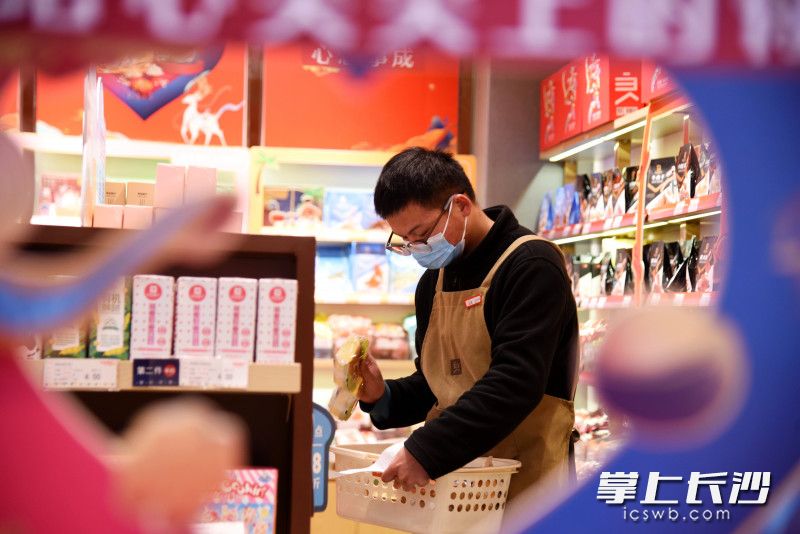 接到外卖订单，良品铺子长沙五一广场店店长刘兴瑞为顾客取货。均为长沙晚报全媒体记者 刘琦 摄