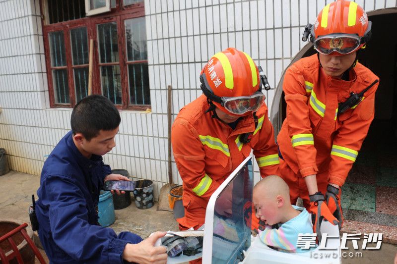 现场，消防员对洗衣机进行破拆，以救出被困的儿童。均为长沙晚报通讯员 胡宇波 供图
