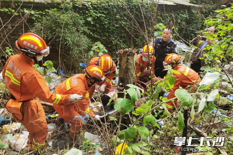 消防员将老人抬出。