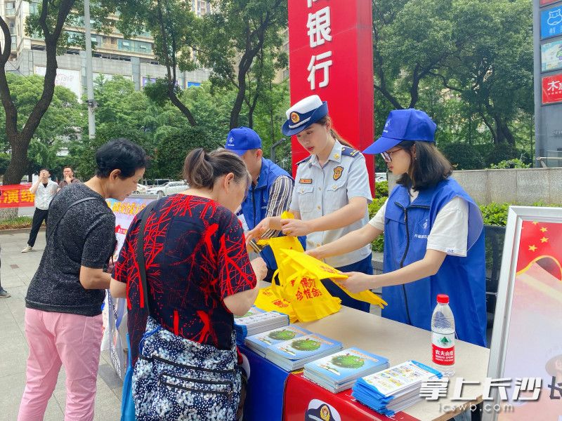 消防宣传员向群众发放宣传材料，讲解消防安全知识。