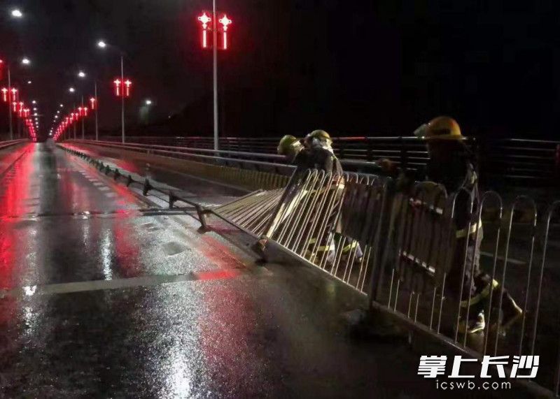 消防队员将倾倒的护栏扶起。 消防队员将倾倒的护栏扶起。