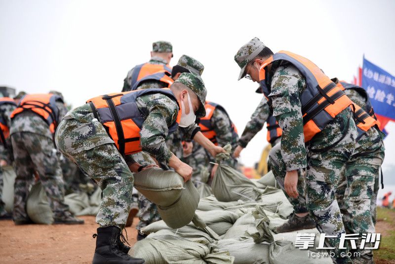 民兵快速装沙袋修筑防洪子堤。