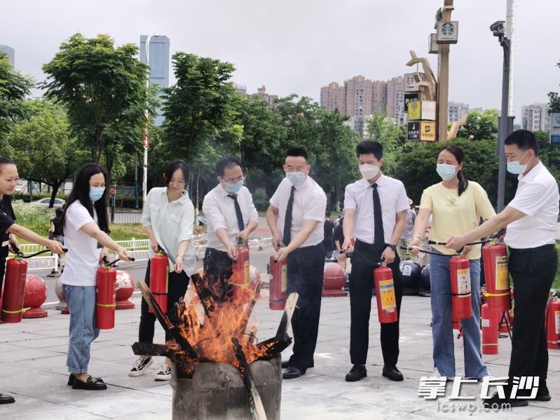 商场员工现场学习灭火技能。