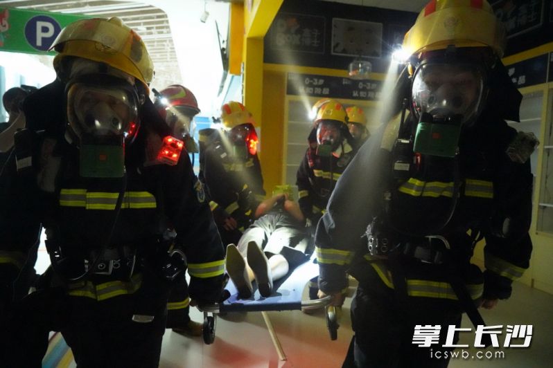 消防救援人员从演练现场救出“被困人员”。