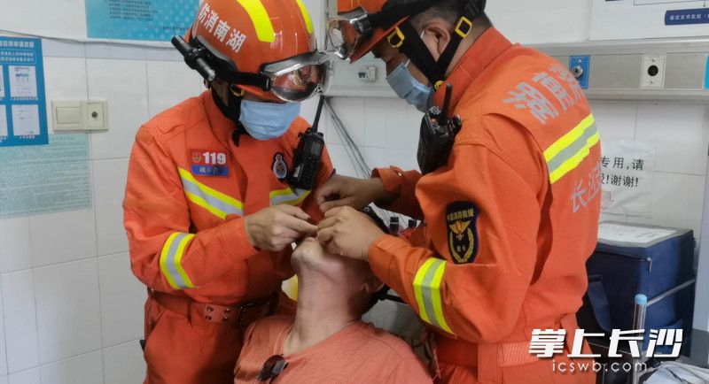 现场，消防救援人员努力摘除鱼钩。长沙晚报通讯员 刘雅莉 供图