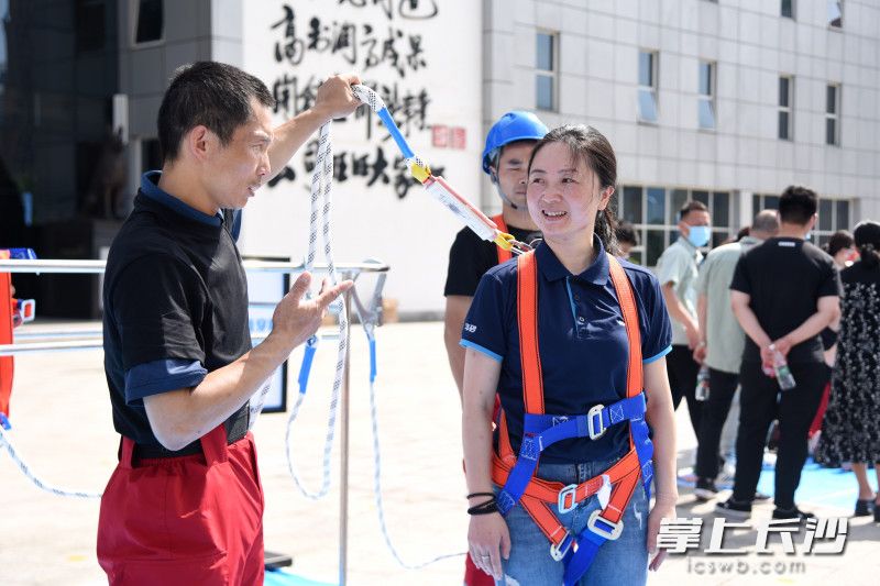 工作人员现场演示安全带的使用方法。