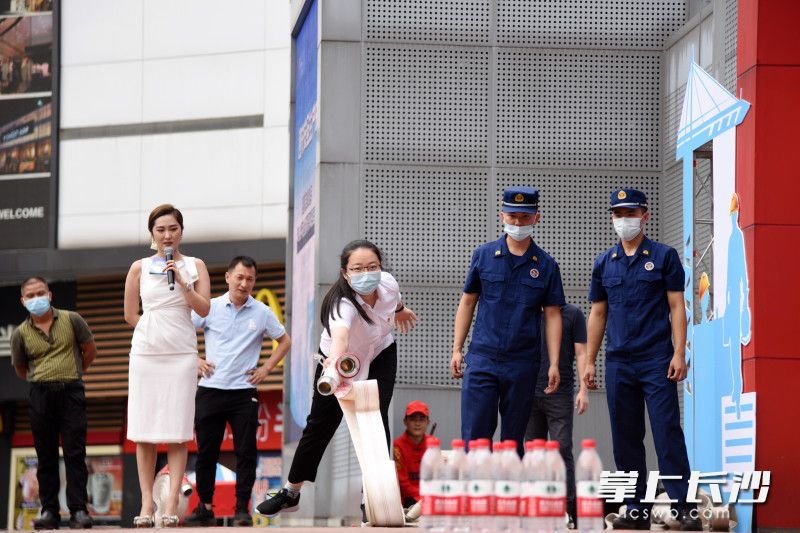 现场观众上台互动，参与“水带保龄球”小游戏，学习消防安全知识。长沙晚报全媒体记者 刘琦 摄