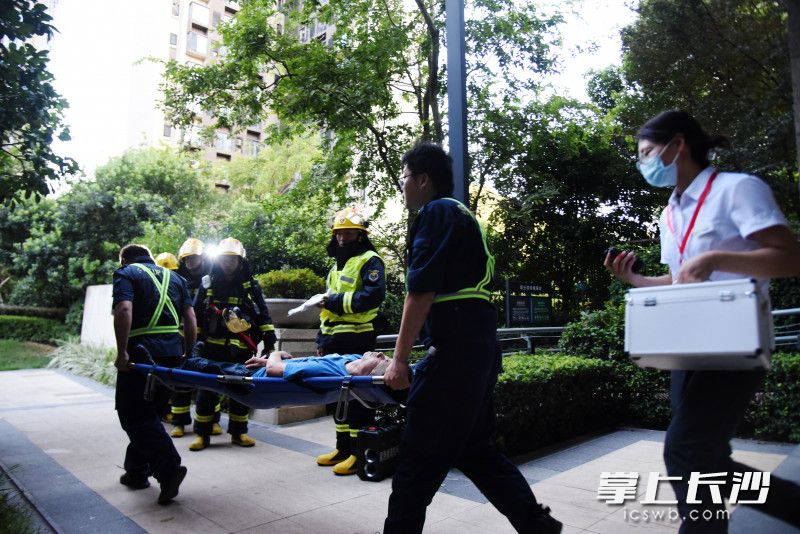 演练中的“伤者”被物业人员从“火场”中抬出。