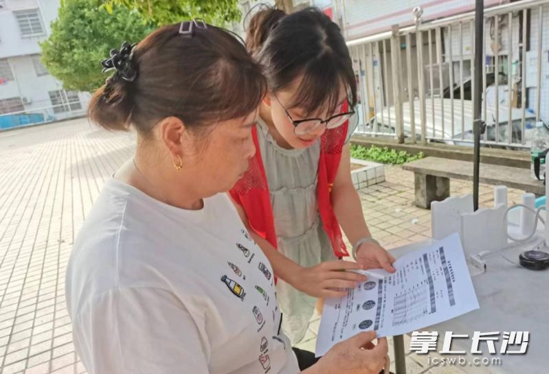 志愿者为居民讲解健康情况。