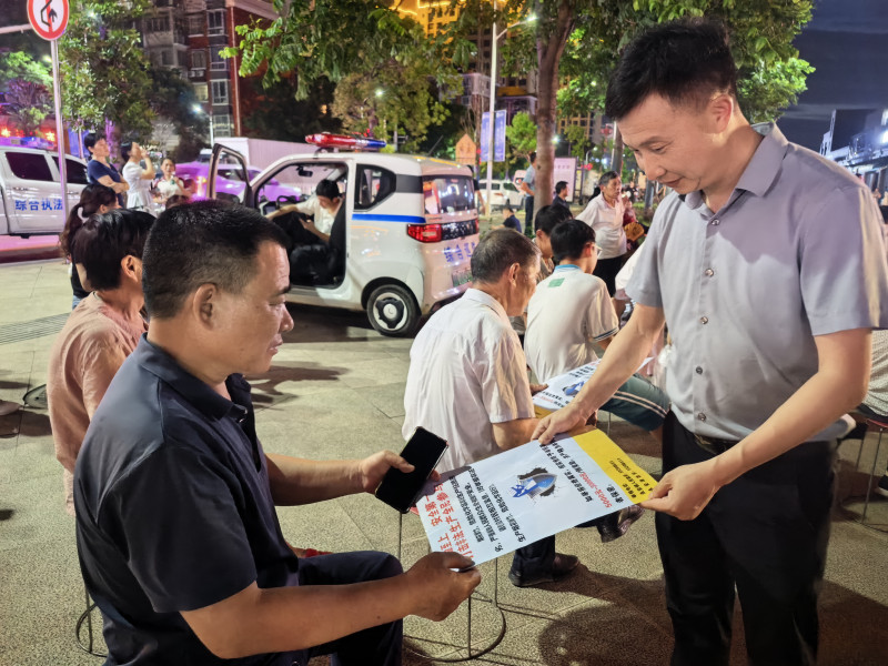 工作人员正向观戏群众发放宣传资料