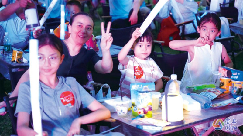 7月12日晚，家长和孩子们在天空剧院观看焰火秀。