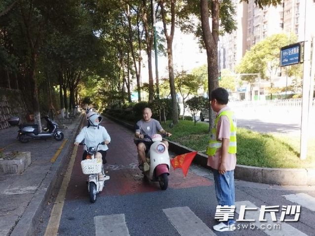 工作人员在辖区重点路口开展“戴帽工程”宣传劝导行动。 长沙晚报通讯员 孙岩岩供图