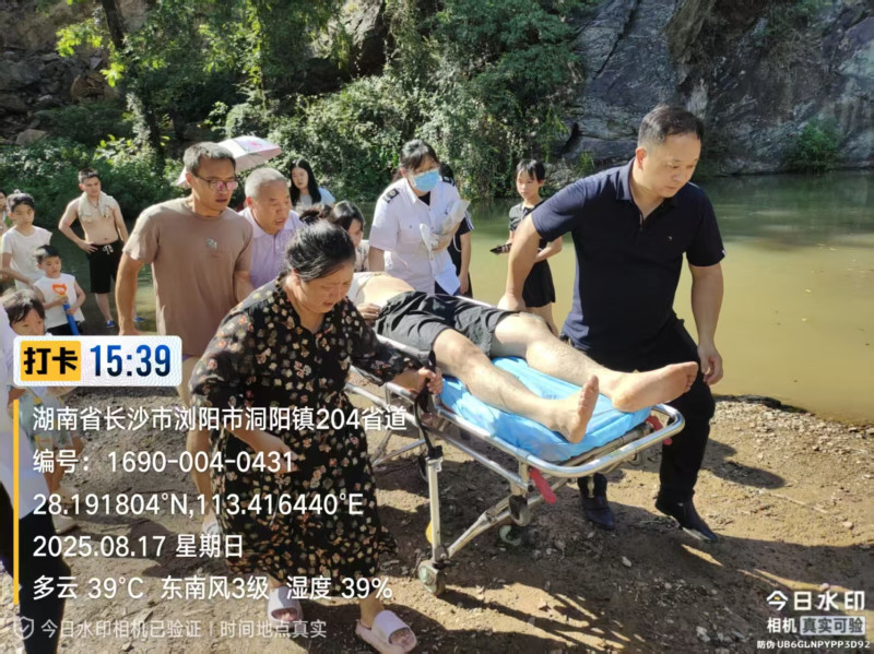 大家合力将溺水男子送往医院进一步救治，画面左上方着黑色短裤者为蔺志广。长沙晚报通讯员 蔺辉供图
