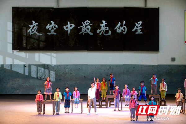 ▲留守儿童在王老师（何炅饰）的带领下共唱《夜空中最亮的星》。